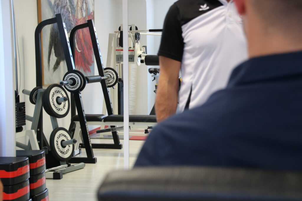 Fisioterapista e paziente nella sala attrezzi del centro fisioterapia in Ticino, Physio Sport Progress